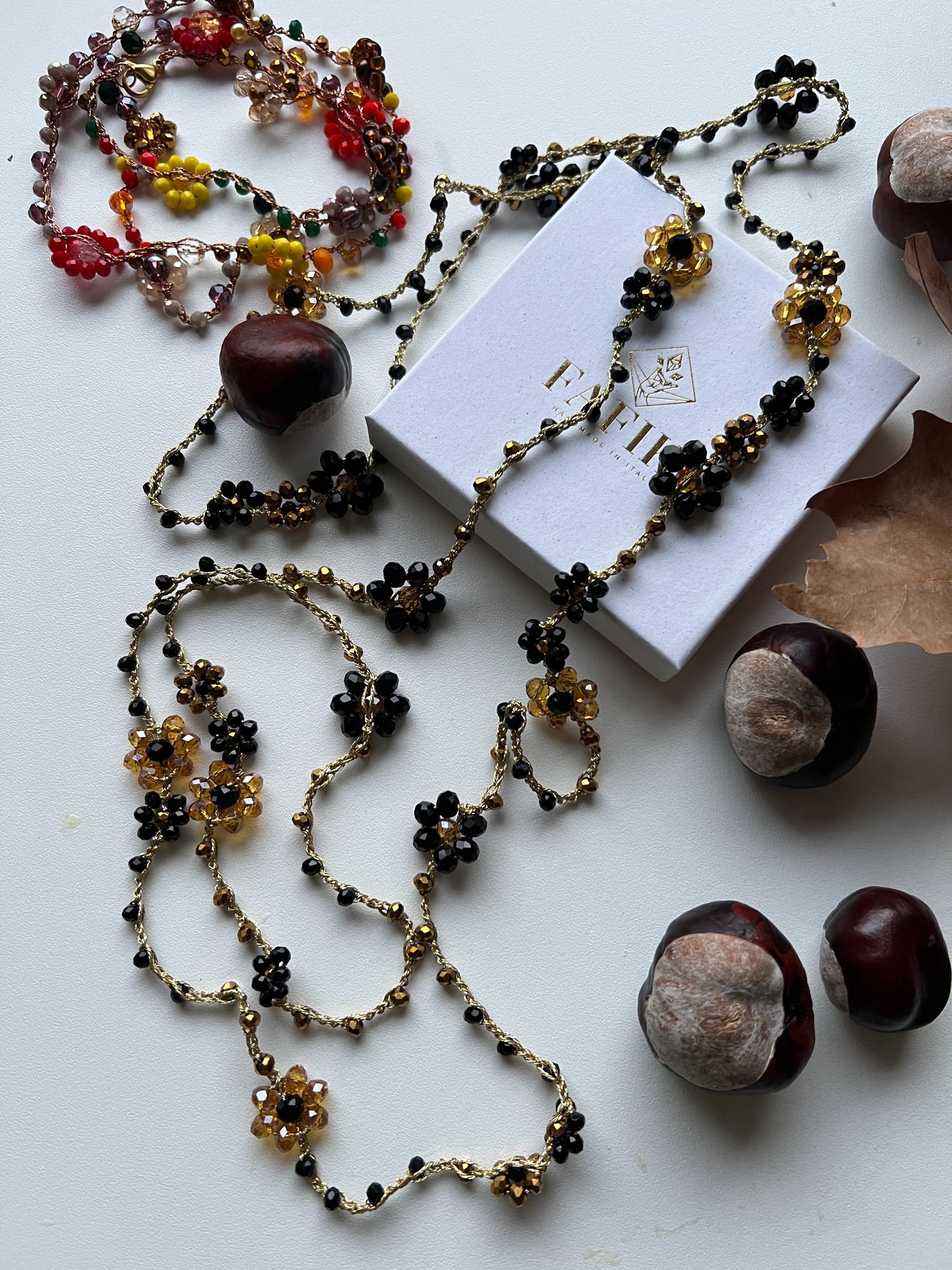 Collana lunga boho chic in oro nero con cristalli e fiori, versatile da indossare come collana o bracciale wrap, perfetta per aggiungere un tocco di eleganza e personalità al tuo look.