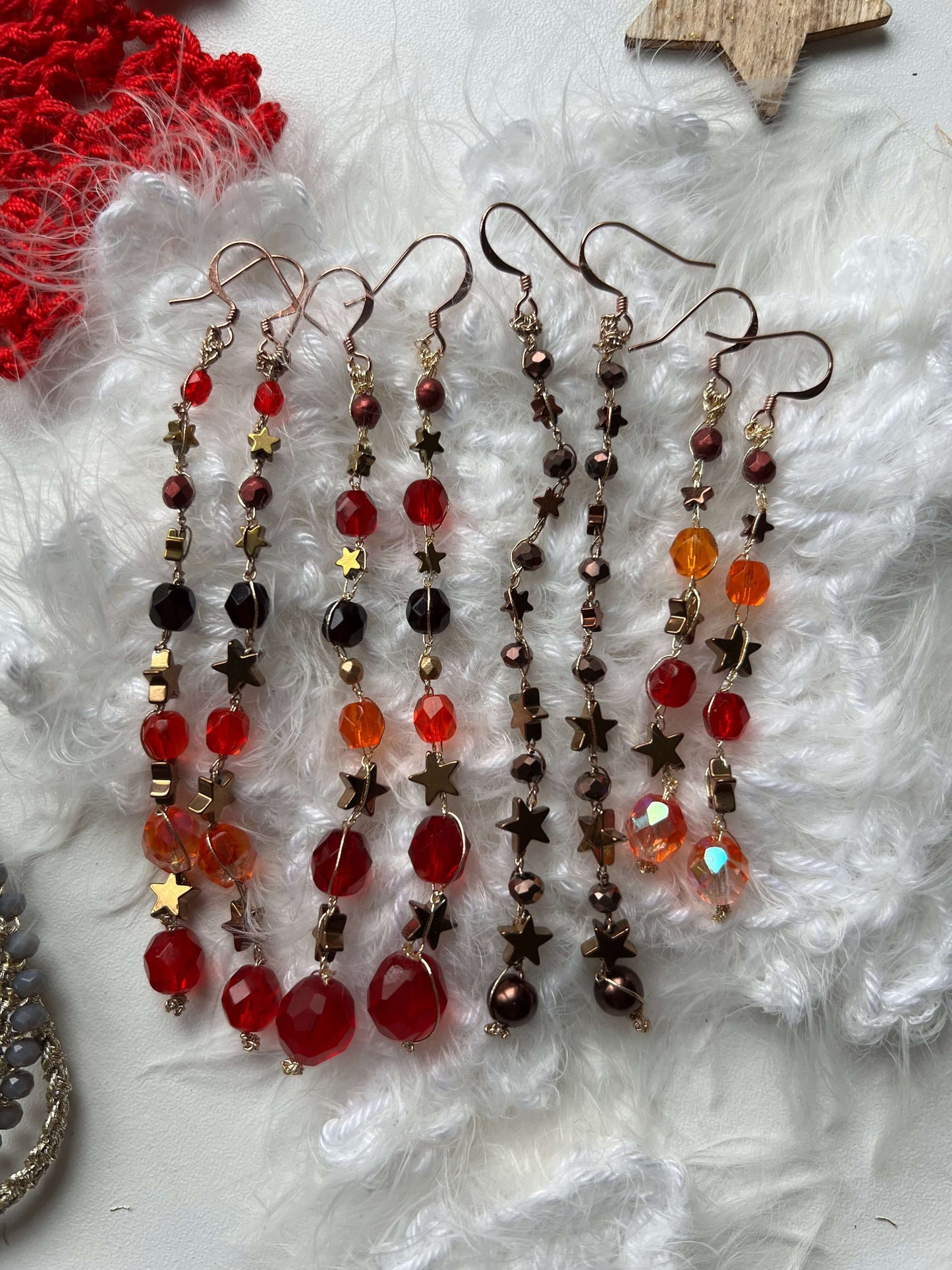 Orecchini stelle rosse e arancio fatti a mano con ematite e perle di vetro. Luminosi, originali, perfetti come regalo unico.