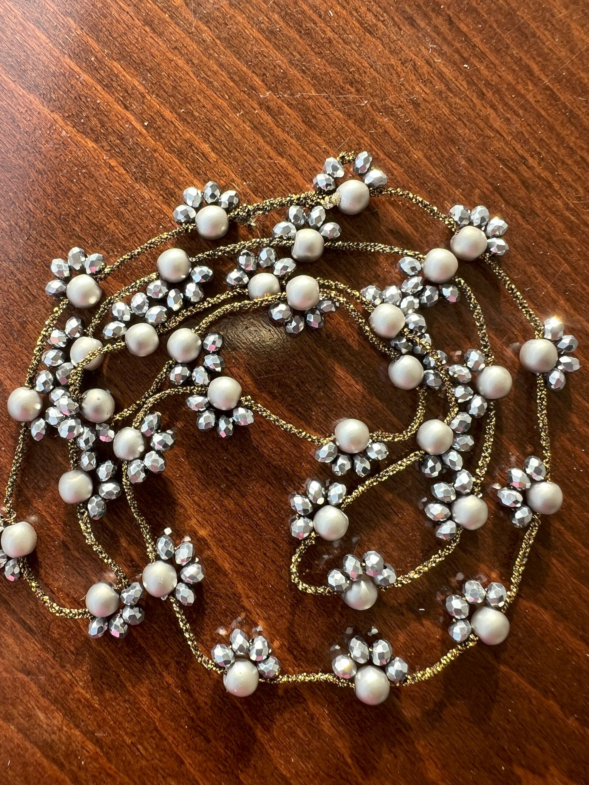 Collana lunga artigianale Filo di Luna in filato gioiello oro-bronzo con cristalli argento e perle di vetro argentato opaco. Accessorio elegante e versatile, indossabile come collana o bracciale avvolgente, perfetta per ogni occasione e stile. Gioiello unico e raffinato, ideale come regalo speciale.