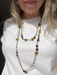 Collana lunga boho chic in oro nero con cristalli e fiori, versatile da indossare come collana o bracciale wrap, perfetta per aggiungere un tocco di eleganza e personalità al tuo look.
