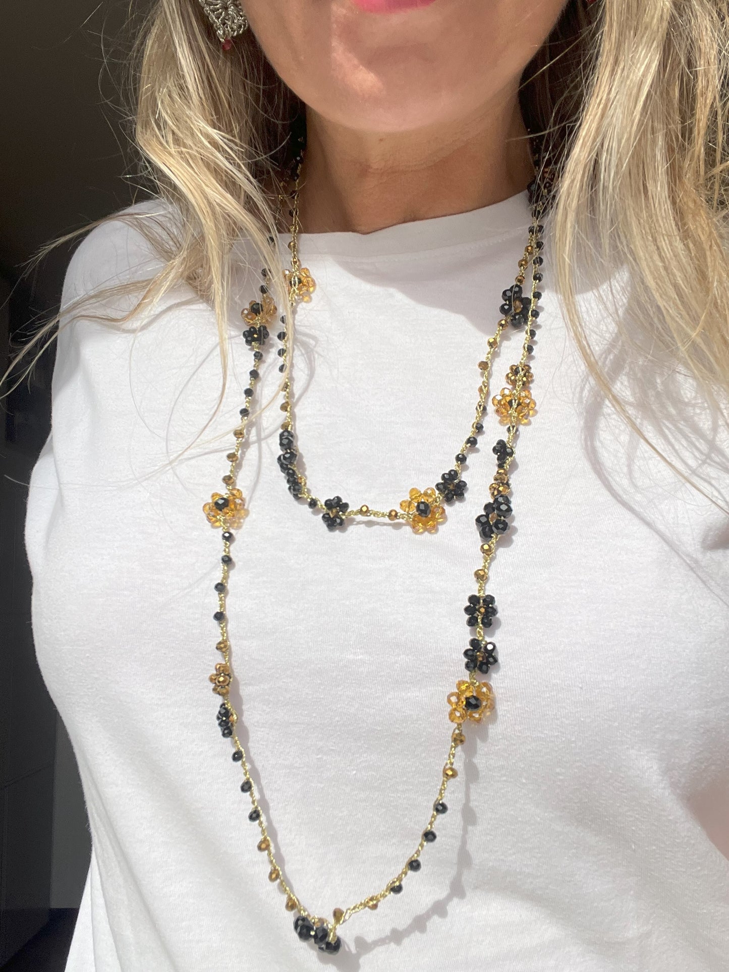 Collana lunga boho chic in oro nero con cristalli e fiori, versatile da indossare come collana o bracciale wrap, perfetta per aggiungere un tocco di eleganza e personalità al tuo look.