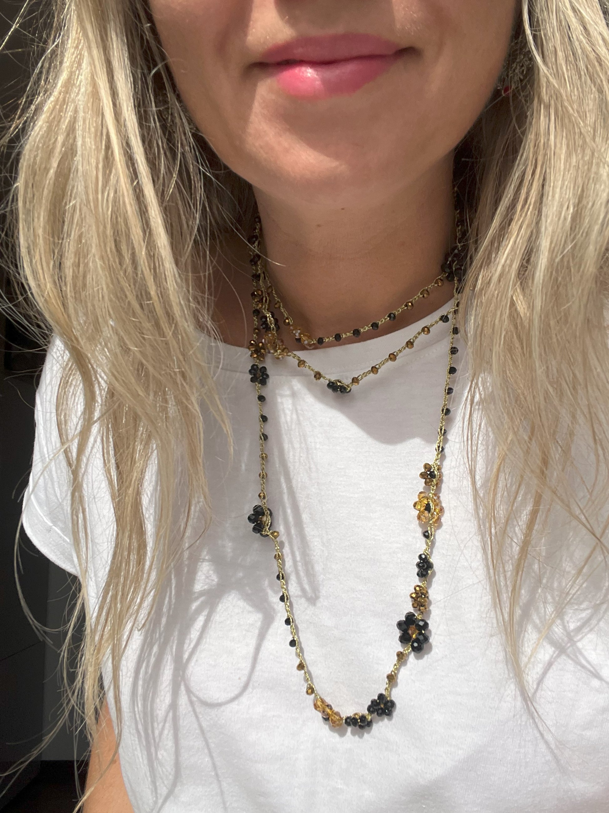 Collana lunga boho chic in oro nero con cristalli e fiori, versatile da indossare come collana o bracciale wrap, perfetta per aggiungere un tocco di eleganza e personalità al tuo look.