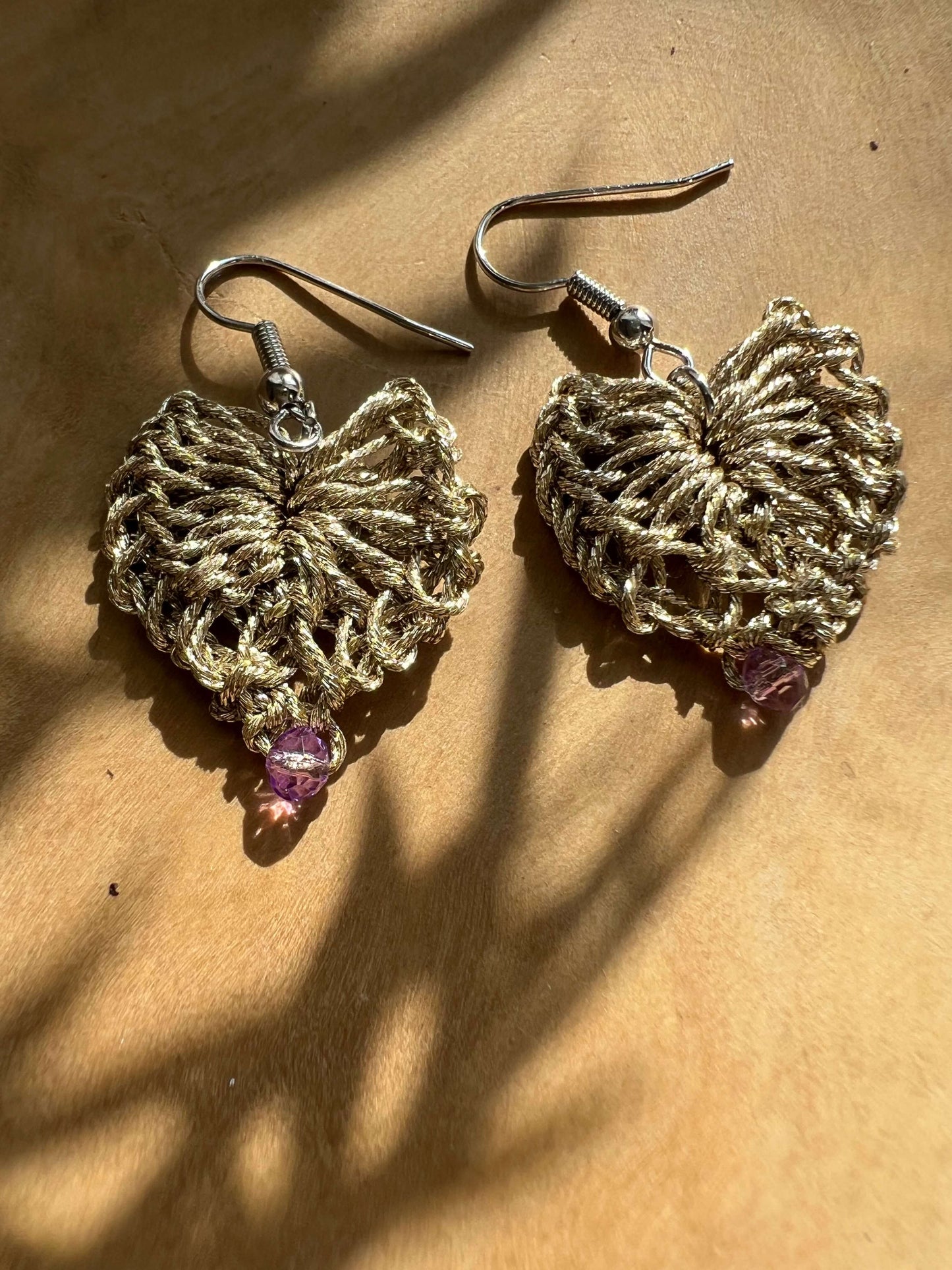 Delicati orecchini a forma di cuore in elegante color oro con un tocco di viola, perfetti per aggiungere un tocco di stile e femminilità a qualsiasi outfit