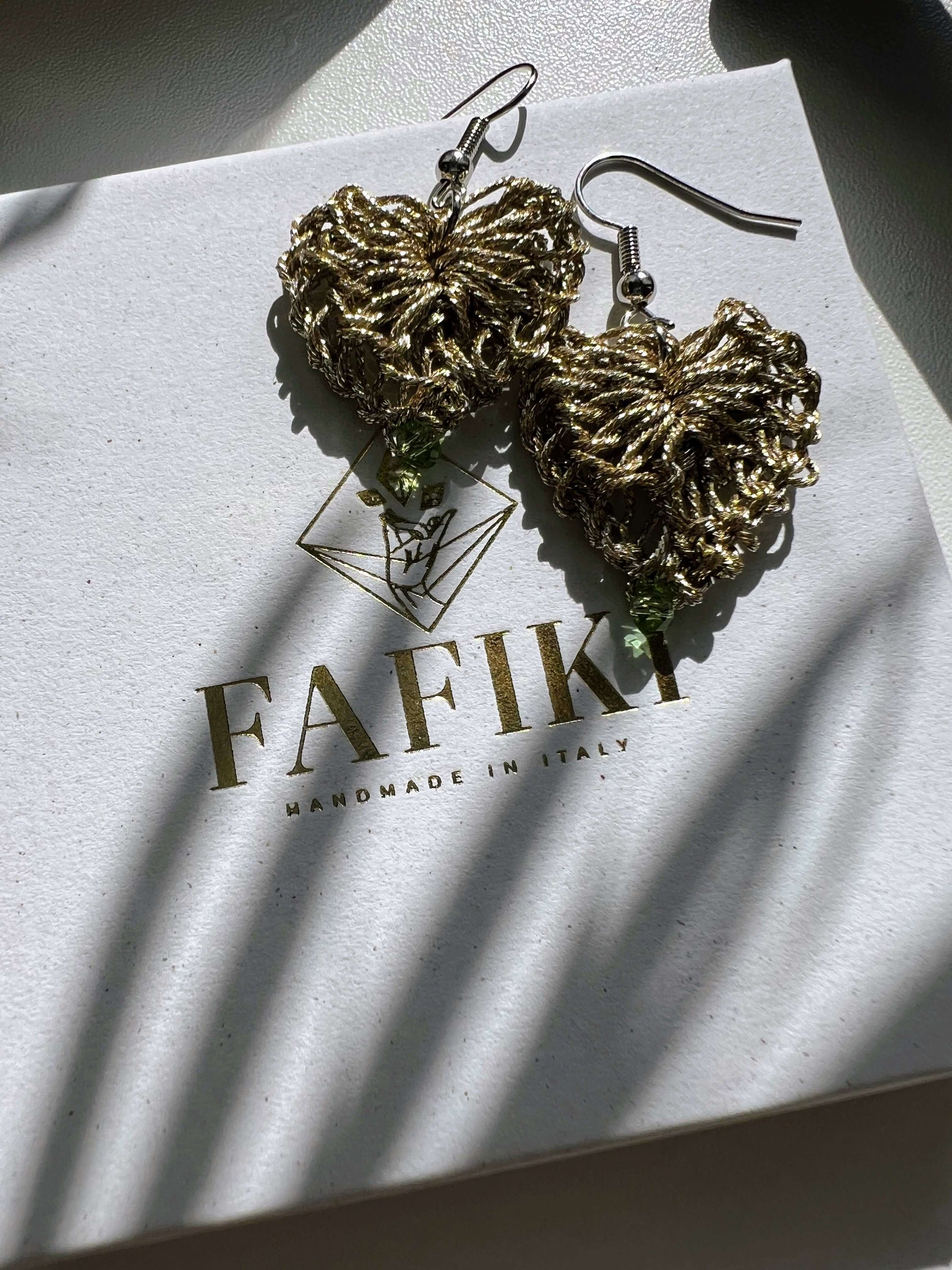 Delicati orecchini a forma di cuore in elegante color oro con un tocco di verde chiaro, perfetti per aggiungere un tocco di stile e femminilità a qualsiasi outfit