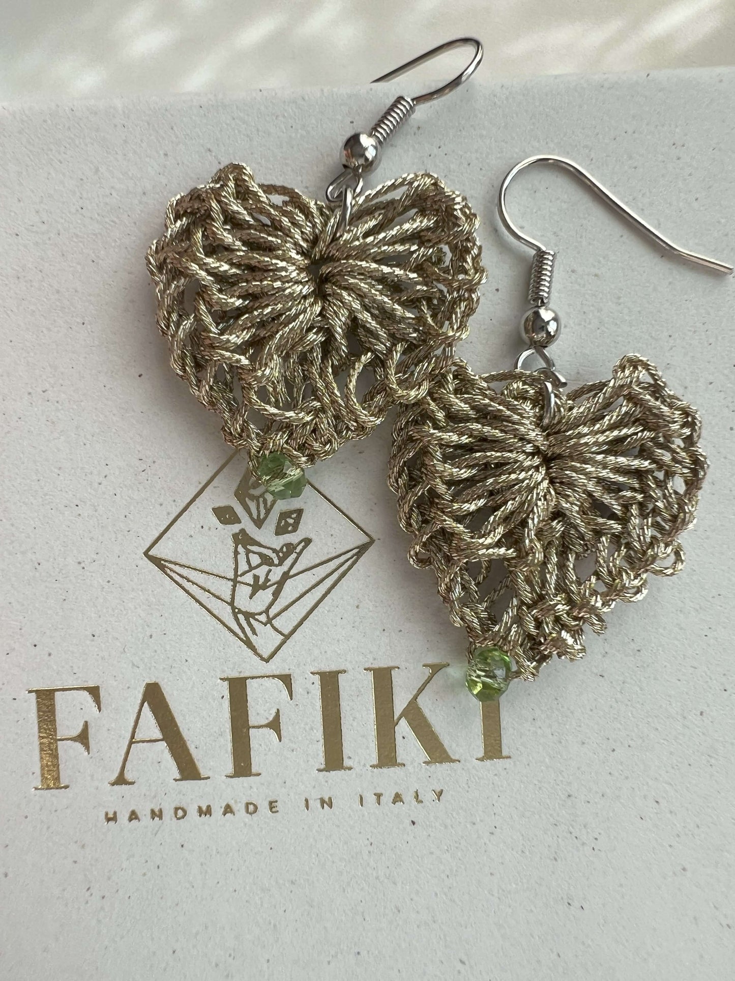 Delicati orecchini a forma di cuore in elegante color oro con un tocco di verde chiaro, perfetti per aggiungere un tocco di stile e femminilità a qualsiasi outfit