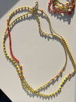Scopri la Collana Mimosa: gioiello artigianale in cristalli arancioni e gialli, versatile da indossare come bracciale. Perfetta per la Festa delle Donne