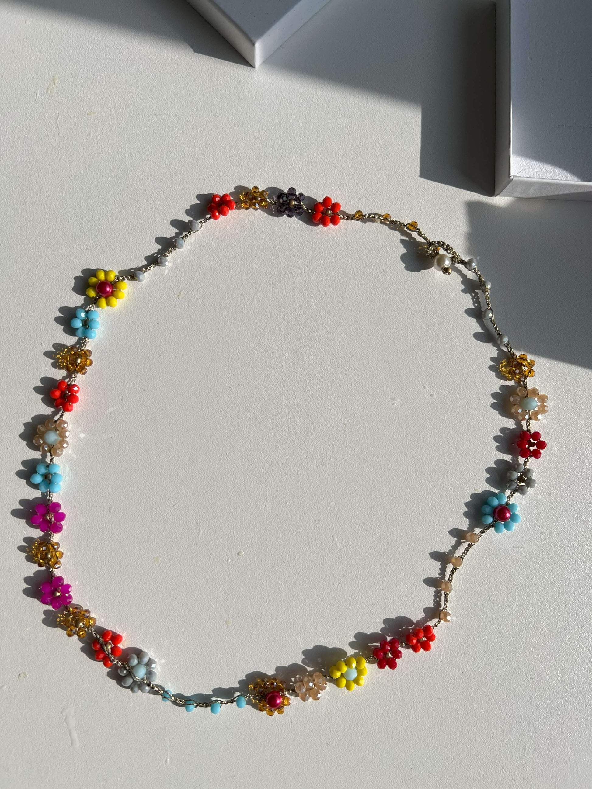 Gioiello fatto a mano Primavera Improvvisa: collana floreale all'uncinetto multicolor. Versatile design convertibile in bracciale wrap, chiusura sicura