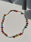 Gioiello fatto a mano Primavera Improvvisa: collana floreale all'uncinetto multicolor. Versatile design convertibile in bracciale wrap, chiusura sicura