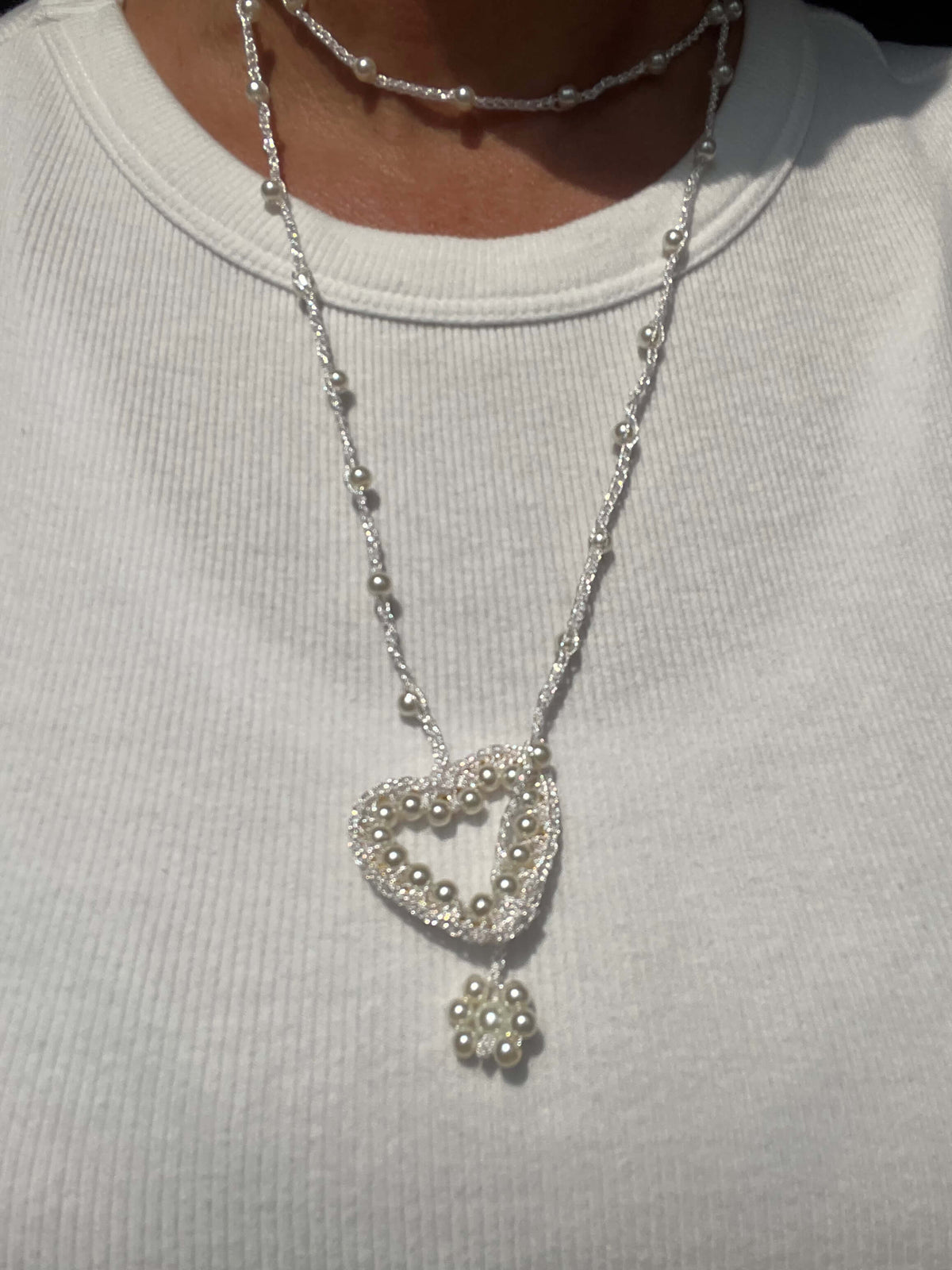 Collana lunga da donna con cuore bianco e perle, gioiello raffinato per un look femminile.