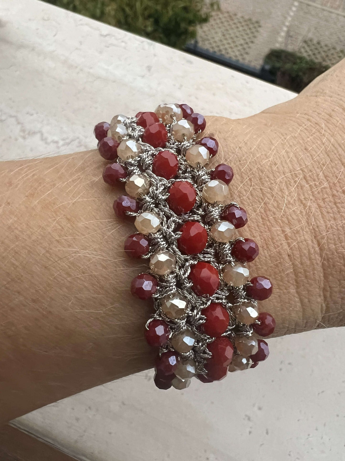 Bracciale fatto a mano in filo platino con cristalli rossi e crema. Luminoso e raffinato, ideale per chi cerca un bracciale elegante da donna.