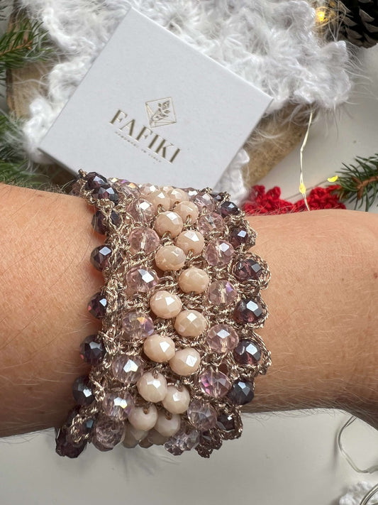 Bracciale elegante con cristalli rosa, viola e crema, filato in oro rosa e chiusura regolabile. Design raffinato, perfetto per chi ama la bellezza naturale