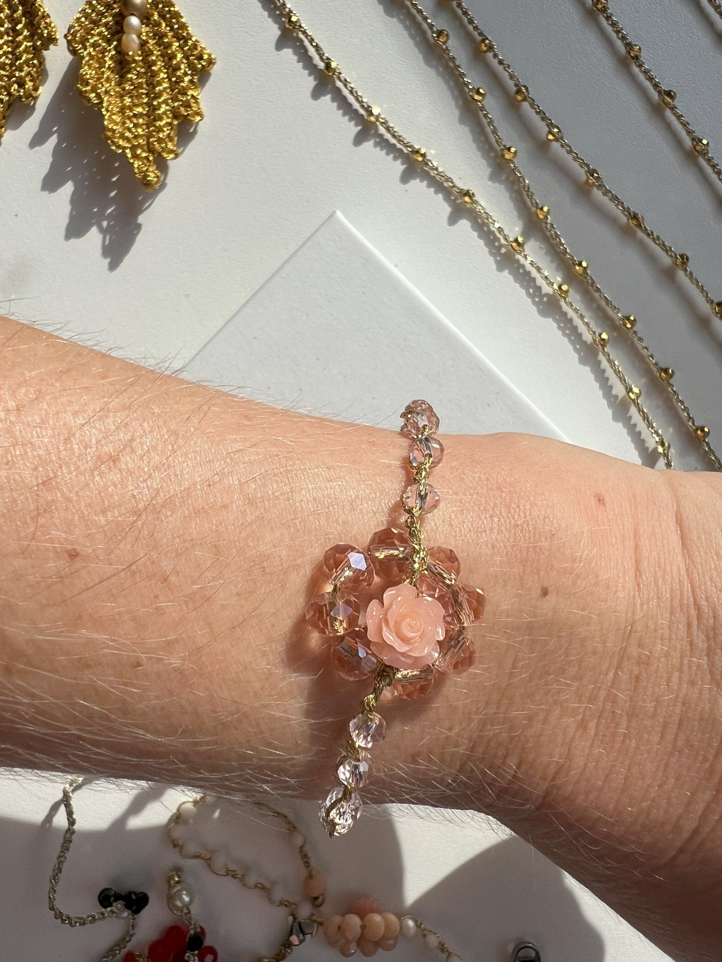 Bracciale elegante regolabile artigianale con cristalli rosa e corallo centrale, perfetto per uno stile raffinato e naturale. Fatto a mano con cura