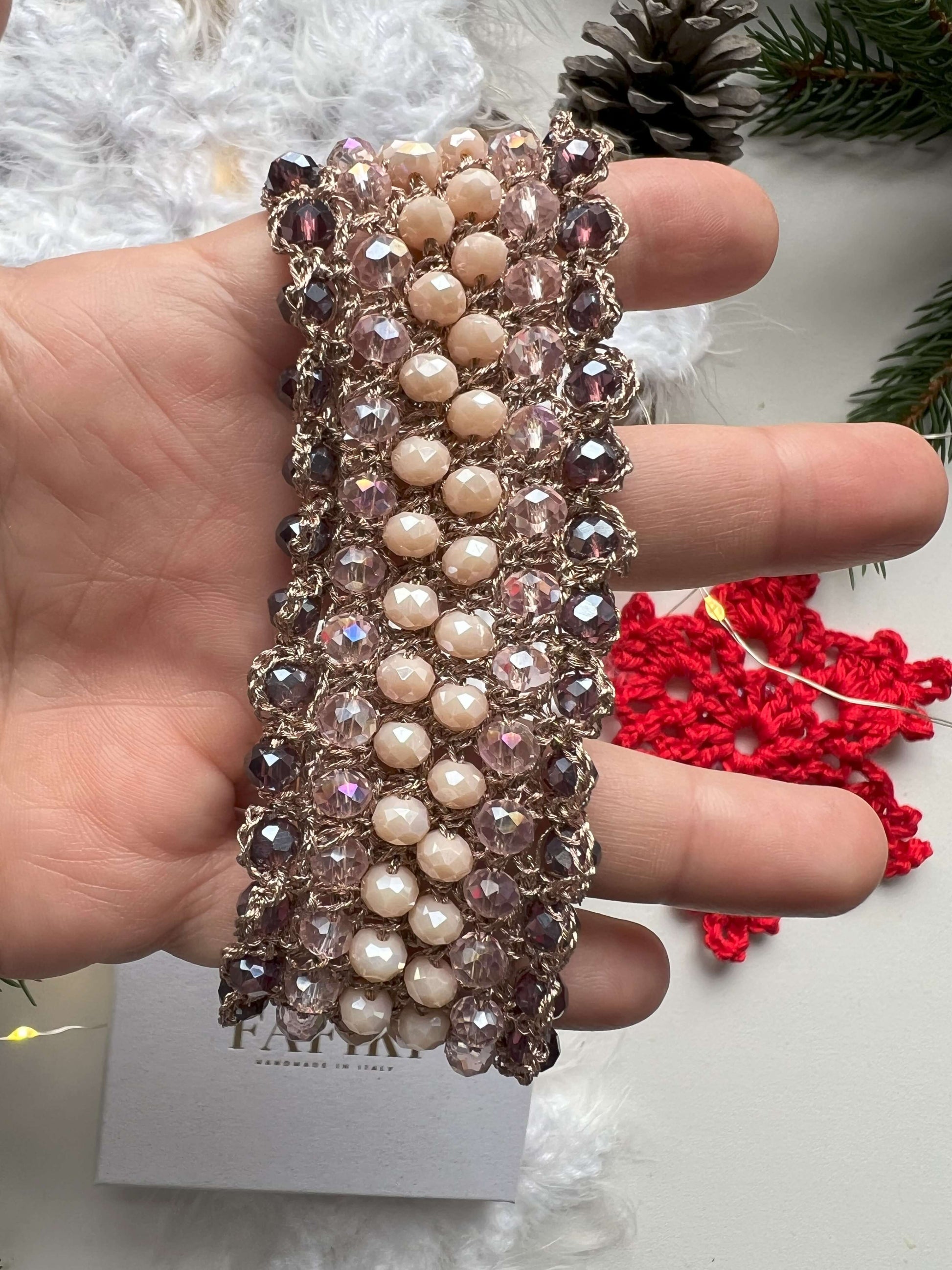 Bracciale elegante con cristalli rosa, viola e crema, filato in oro rosa e chiusura regolabile. Design raffinato, perfetto per tutte le taglie