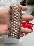 Bracciale elegante con cristalli rosa, viola e crema, filato in oro rosa e chiusura regolabile. Design raffinato, perfetto per tutte le taglie