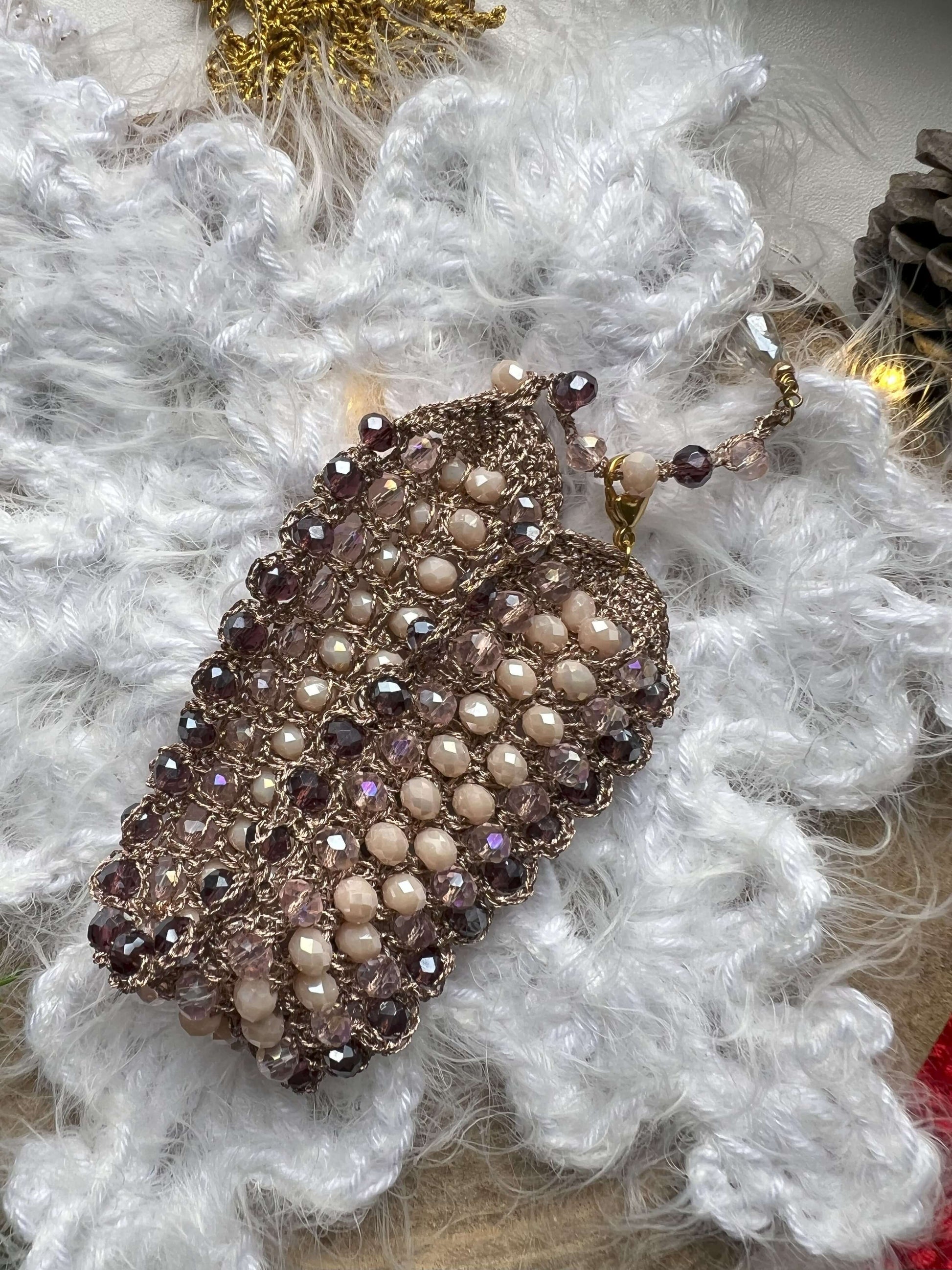 Bracciale elegante con cristalli rosa, viola e crema, filato in oro rosa e chiusura regolabile. Design raffinato, perfetto come regalo di natale