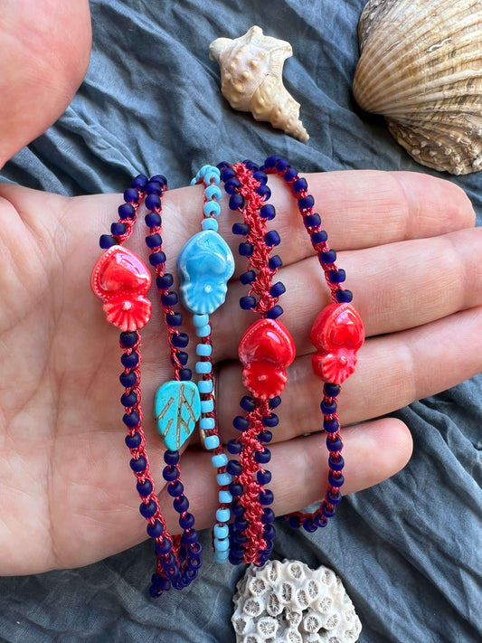 Bracciali Yana fatti a mano boho in rosso e blu con ciondolo simbolico (tartaruga, foglia o cuore), leggeri e regolabili, spirituali e unici.