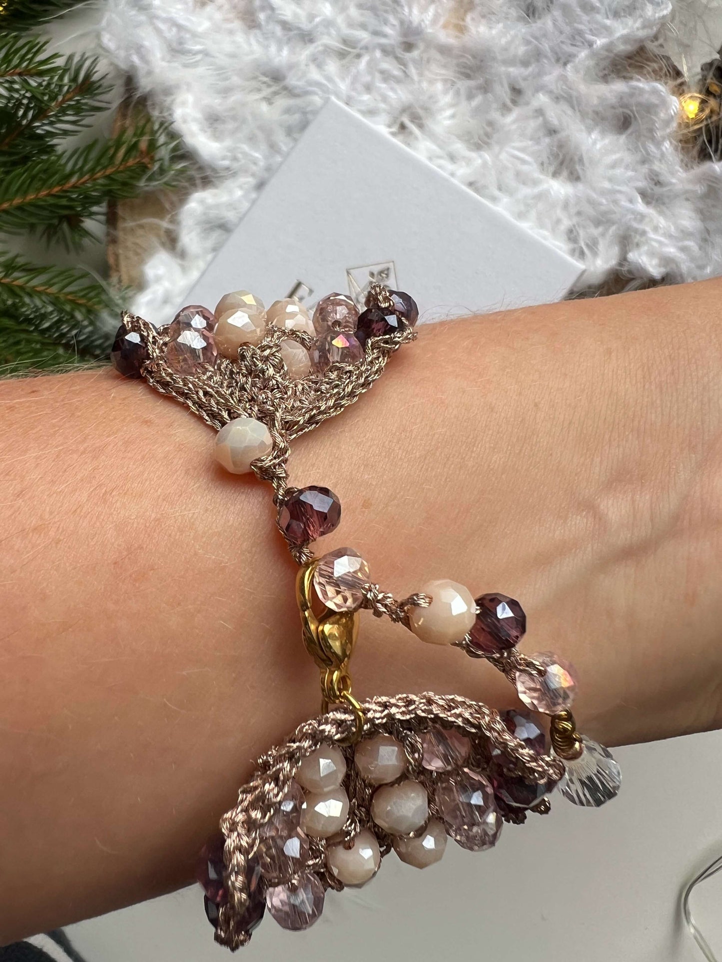 Bracciale elegante con cristalli rosa, viola e crema, filato in oro rosa e chiusura regolabile. Design raffinato, perfetto per regalo di natale