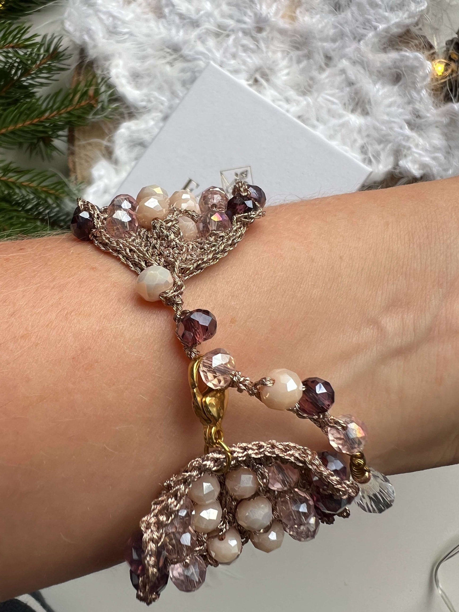 Bracciale elegante con cristalli rosa, viola e crema, filato in oro rosa e chiusura regolabile. Design raffinato, perfetto per regalo di natale