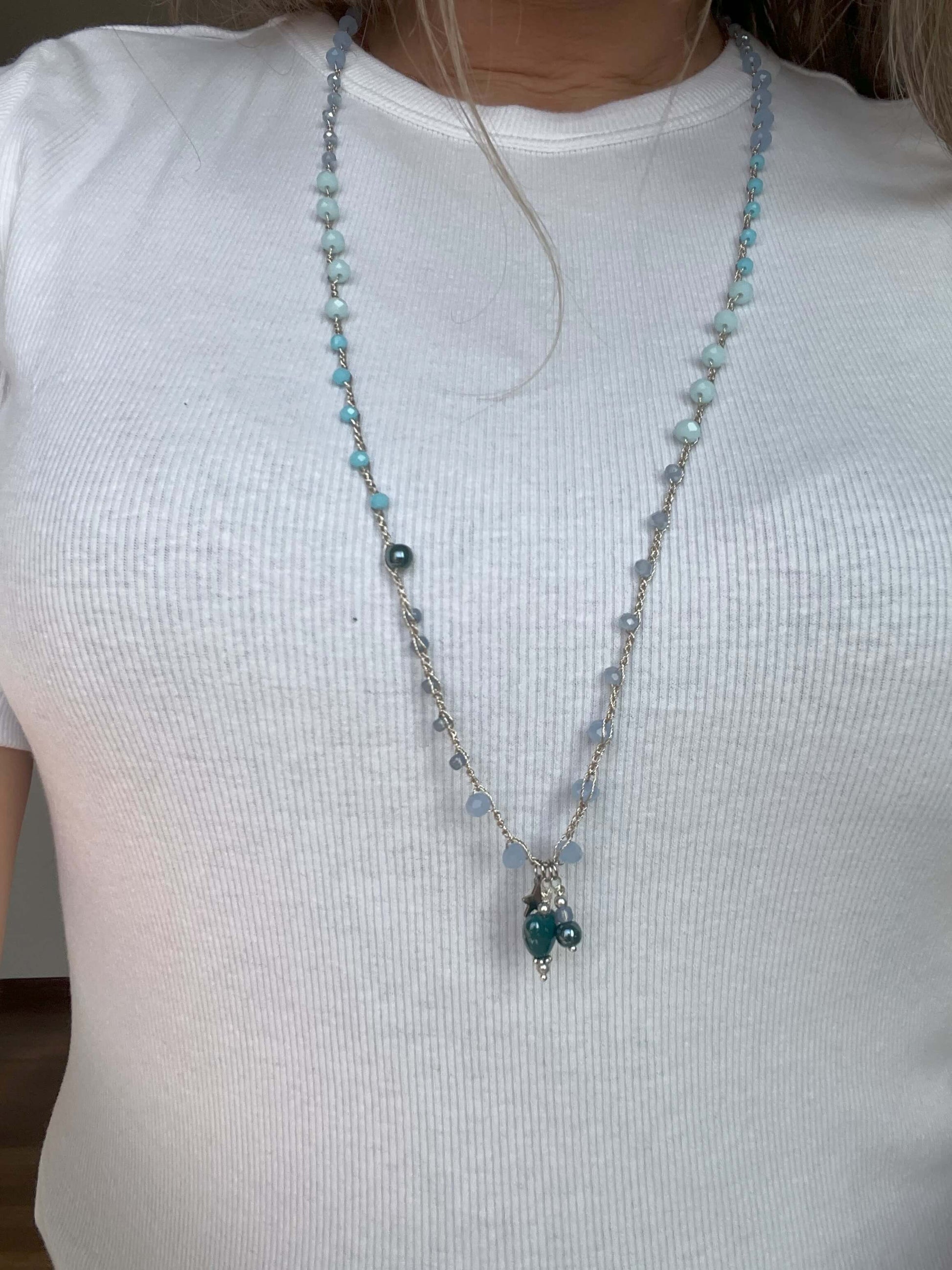 Collana artigianale Cuore di Laguna con cristalli azzurri e ciondoli in ceramica indossata come gioiello elegante