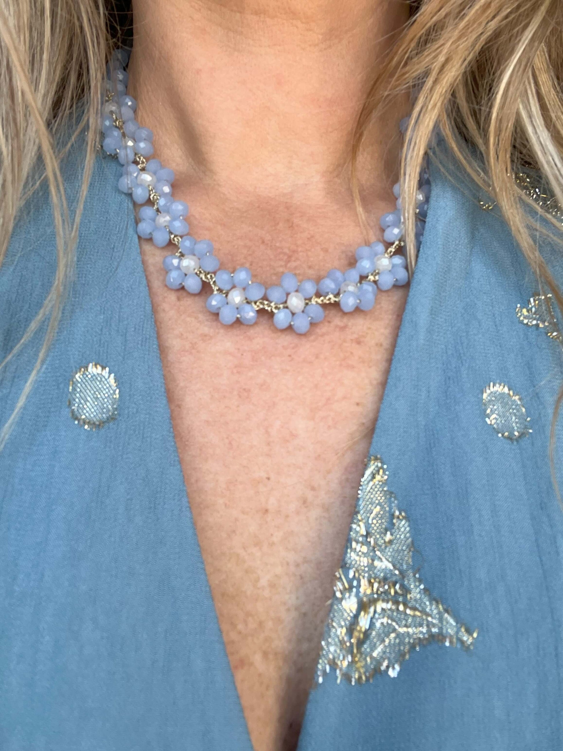 Collana floreale artigianale con fiori azzurro polvere e chiusura a cuore. Romantica, fatta a mano, perfetta per un look elegante e femminile