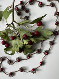 Collana lunga senza chiusura, con perle di vetro color vino e cristalli. Un gioiello elegante che avvolge il collo con stile e raffinatezza naturale