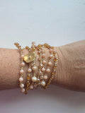 Collana boho Soleil Bloom con doppio filo di cristalli oro, bottone fiore. Elegante, versatile, da indossare come collana o bracciale multigiro.