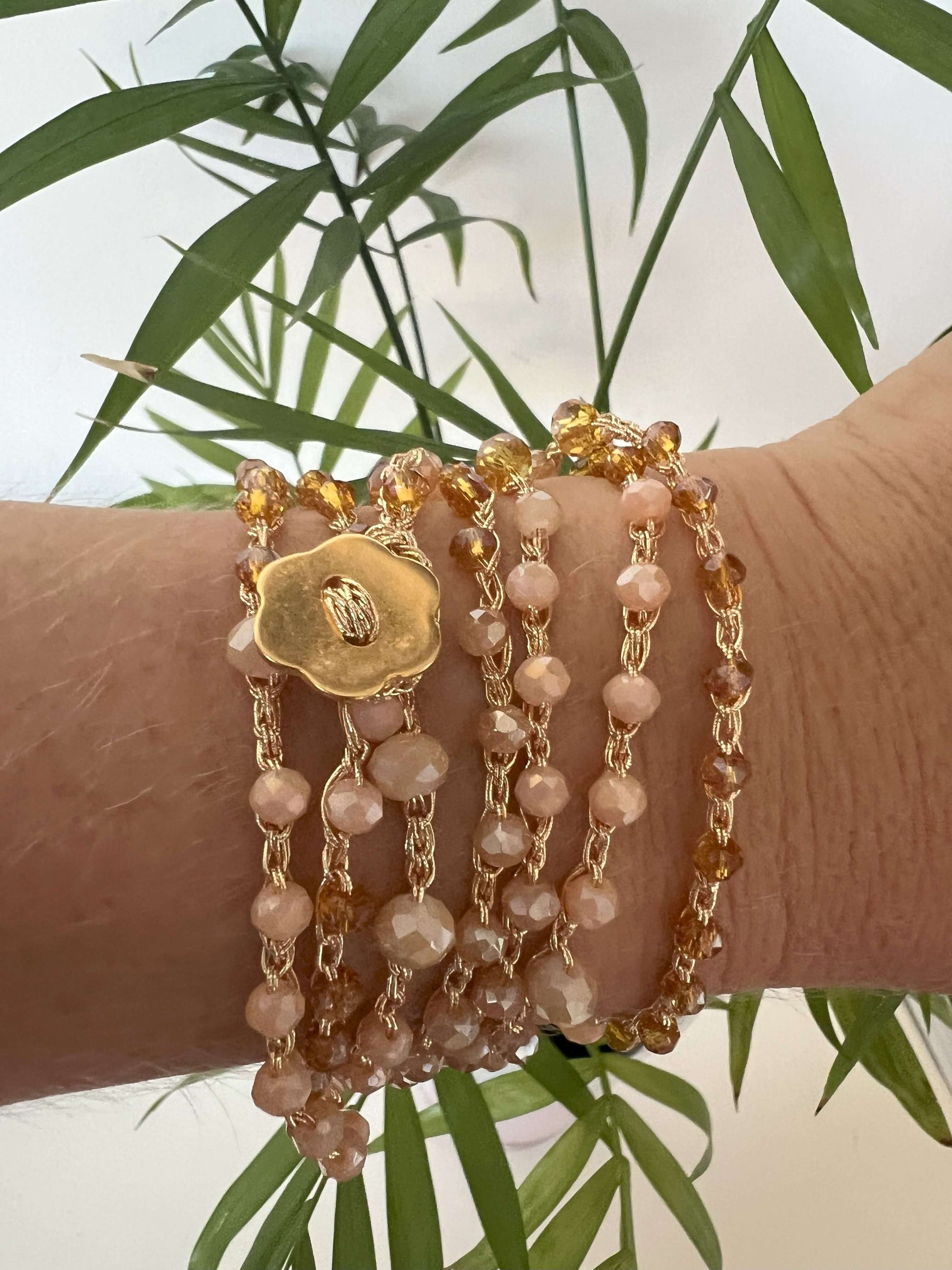 Collana Soleil Bloom doppio filo con cristalli oro e bottone fiore. Gioiello boho versatile, ideale da portare al collo o come bracciale multigiro.