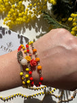 Scopri Mimosa: la collana corta 2 in 1, convertibile in bracciale, impreziosita da 2 rosseline di corallo gialla e arancione, regalo per la festa delle donne