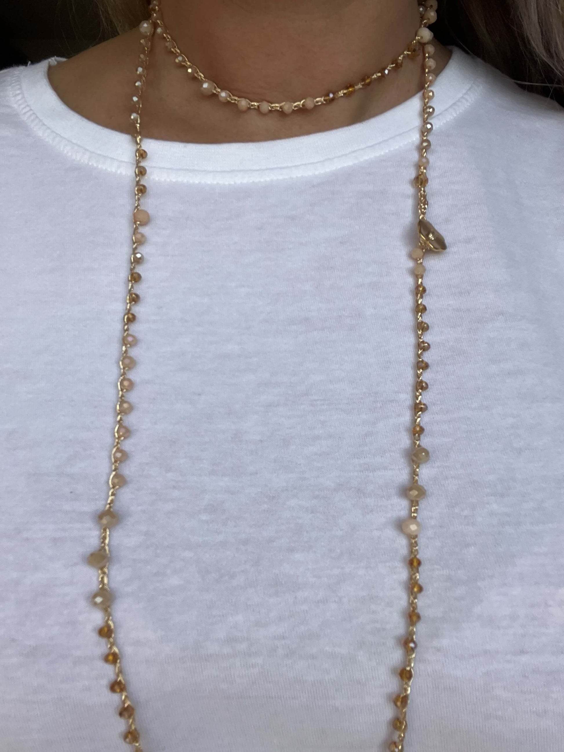 Scopri Soleil Bloom, collana boho chic handmade con cristalli dorati e bottone floreale. Senza metallo, elegante e delicata.