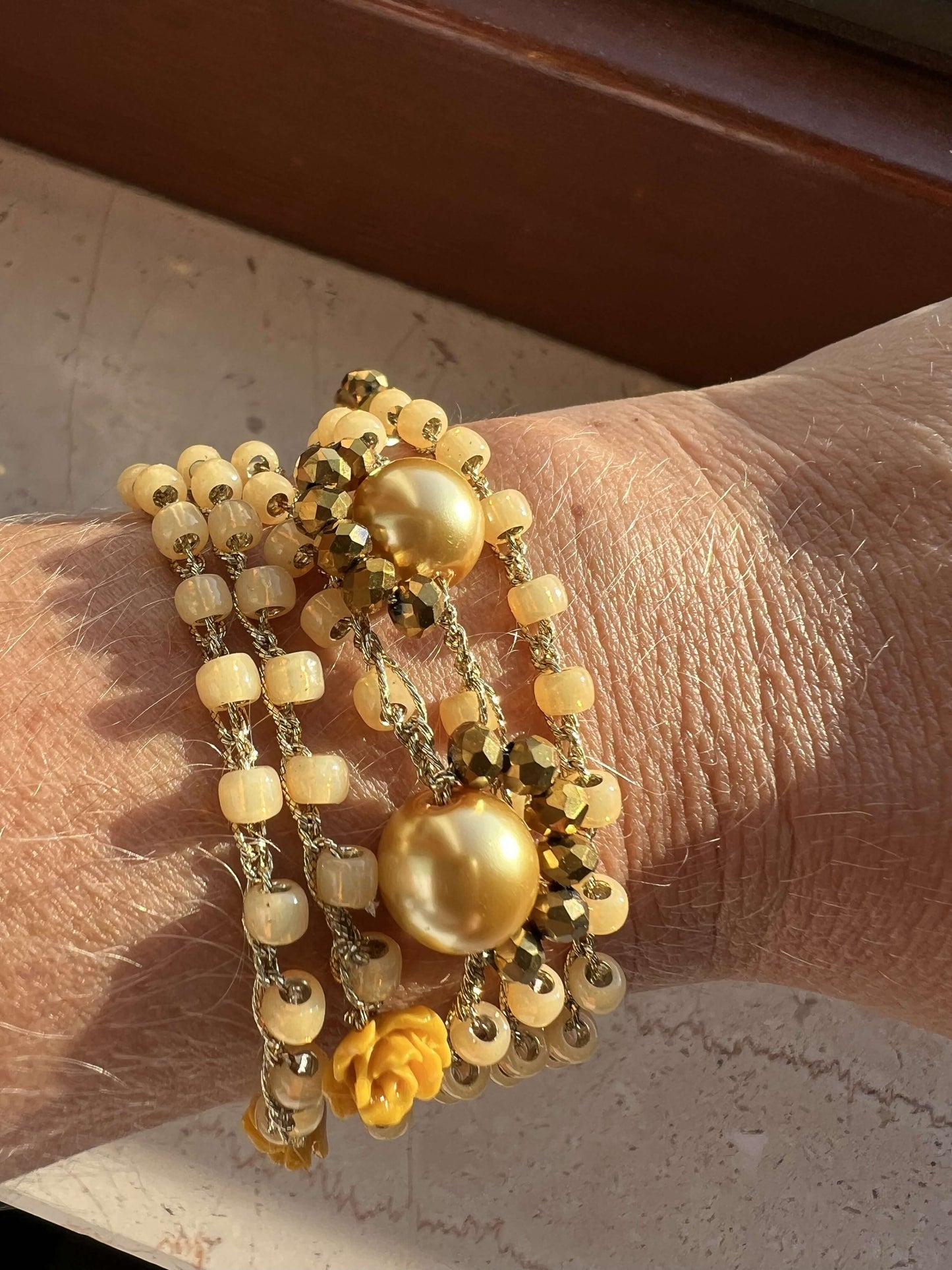 Gioiello fatto a mano in perline Toho miele senape indossato come bracciale avvolgente, ipoallergenico e sostenibile, artigianato italiano.