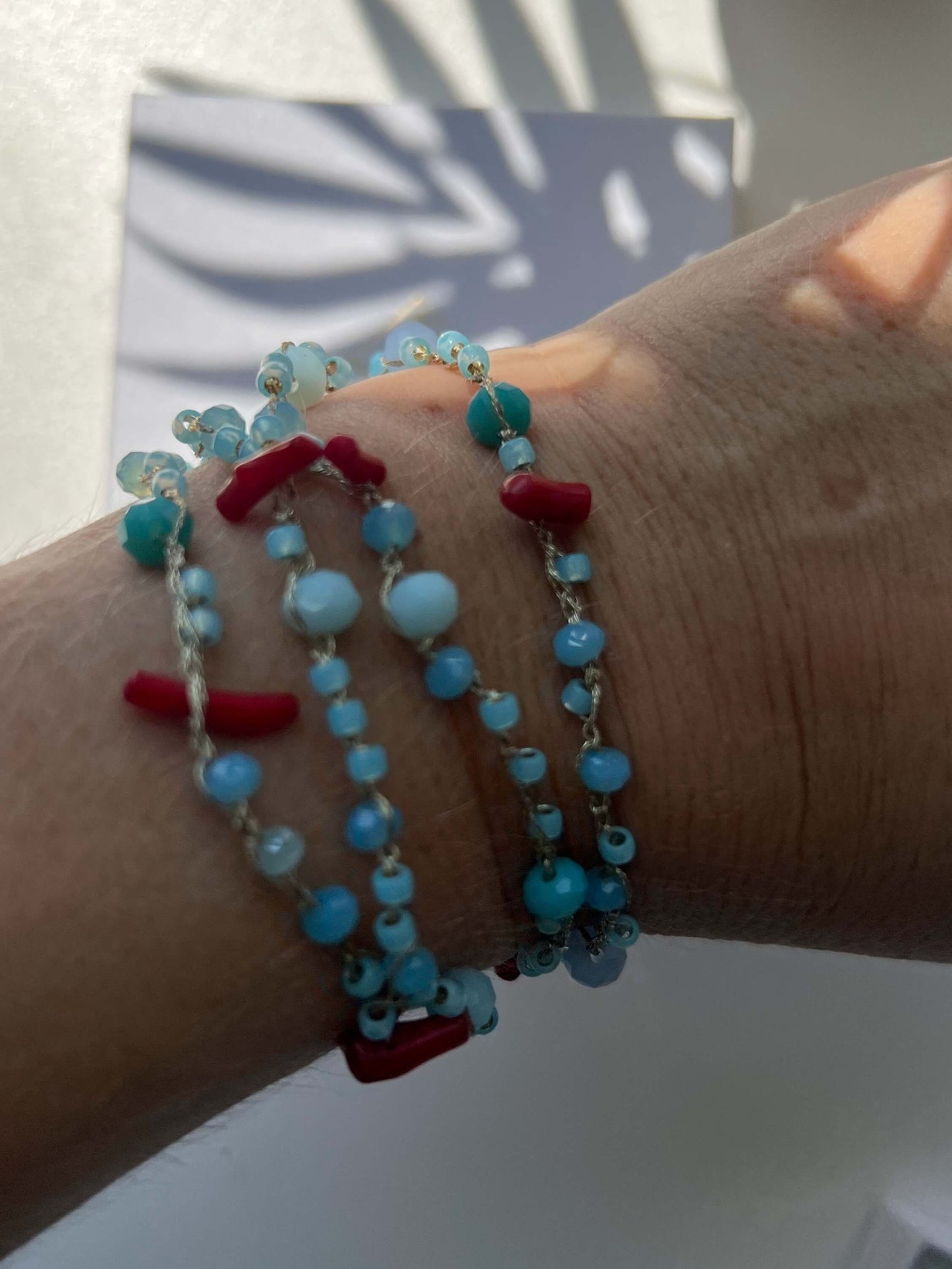 Collana artigianale boho lunga con corallo rosso e azzurro mare. Filato italiano finissimo, ipoallergenica, leggera e versatile per ogni look.
