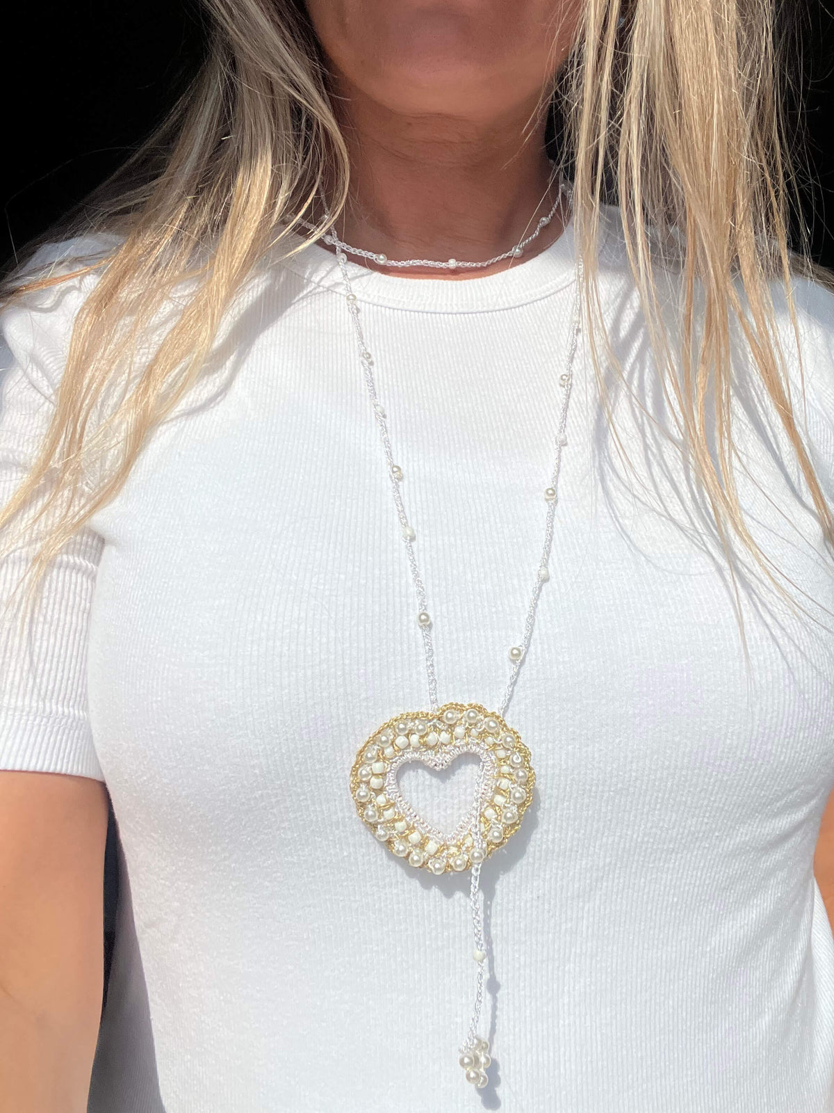 Collana lunga elegante da donna con cuore bianco, perfetta per valorizzare look raffinati.
