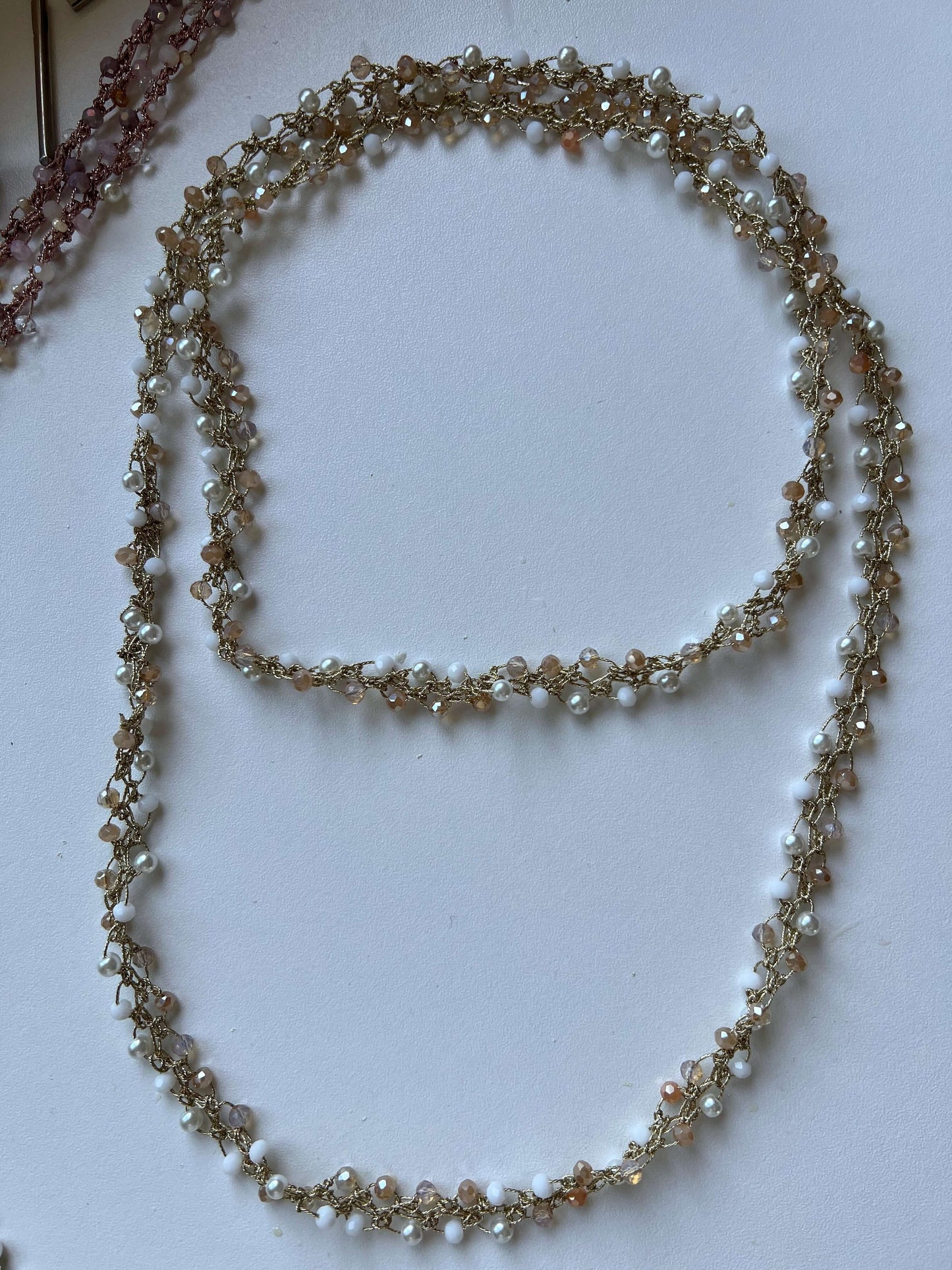 Collana boho oro con cristalli bianchi fatta a mano. Indossala lunga, a doppio giro o come bracciale. Versatile e piena di libertà.