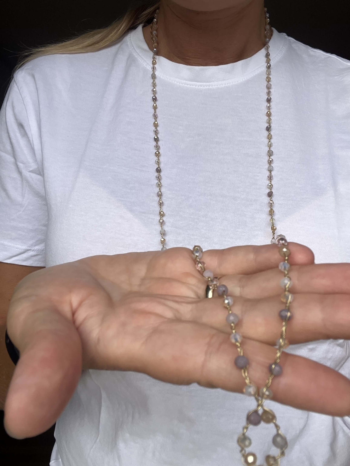 Collana lunga in cristalli viola, beige e crema: leggera dettaglio da vicino