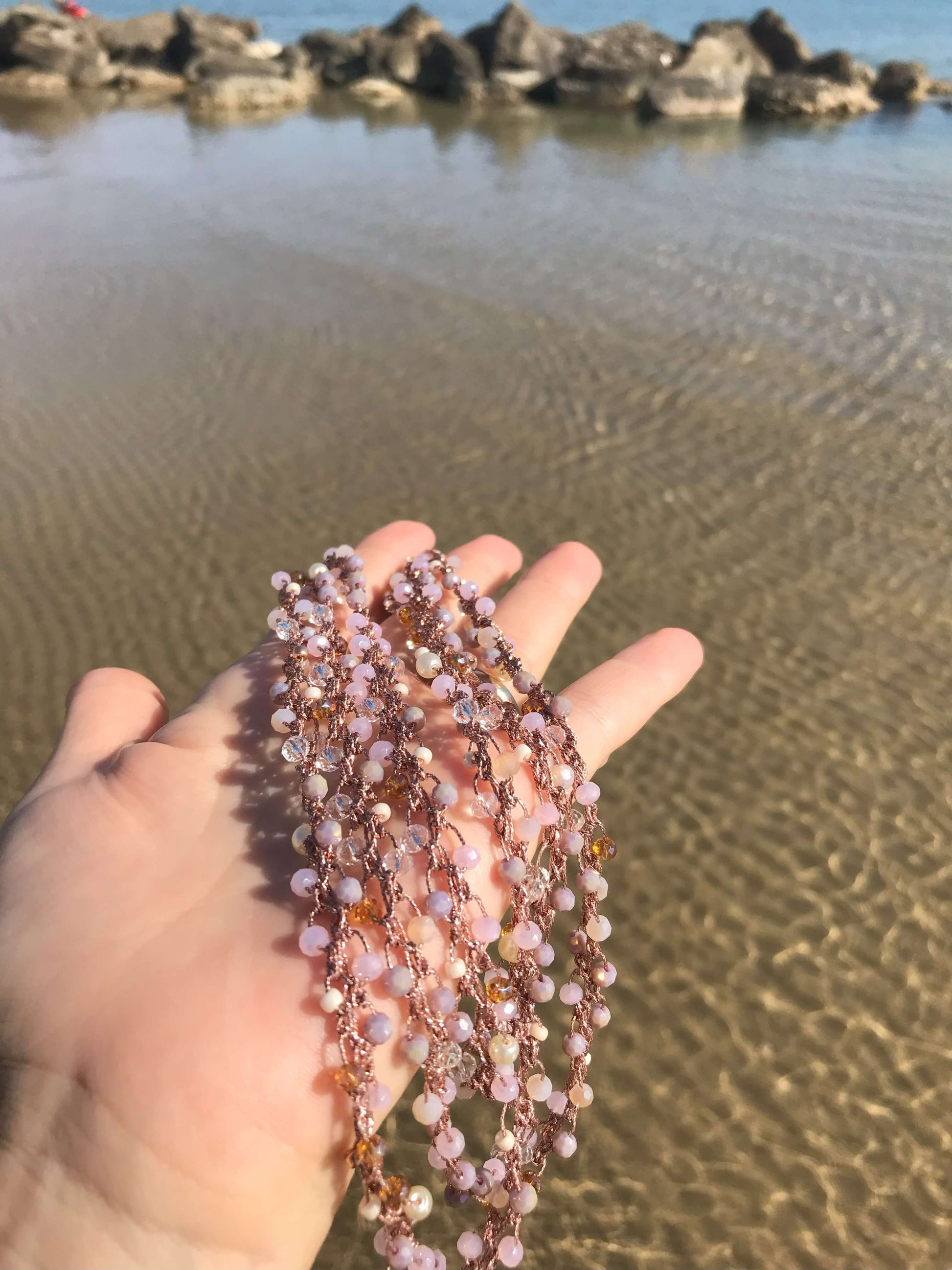 Collana lunga boho chic in oro rosa e cristalli intrecciata all’uncinetto. Tre modi di indossarla, infinite emozioni da vivere.