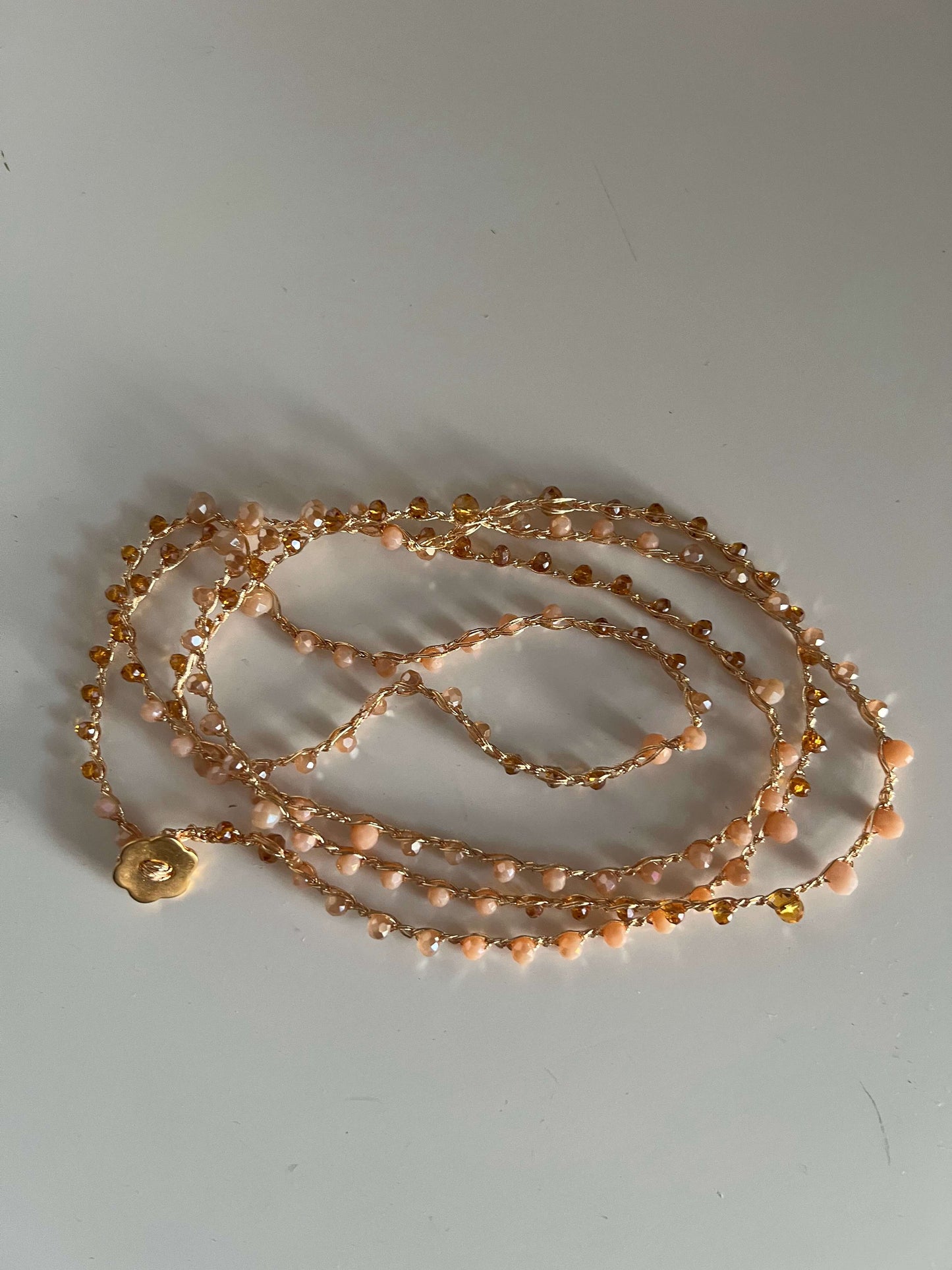 Accessorio boho Soleil Bloom con cristalli dorati e bottone fiore. Collana o bracciale multigiro, elegante e leggero, perfetto per ogni occasione