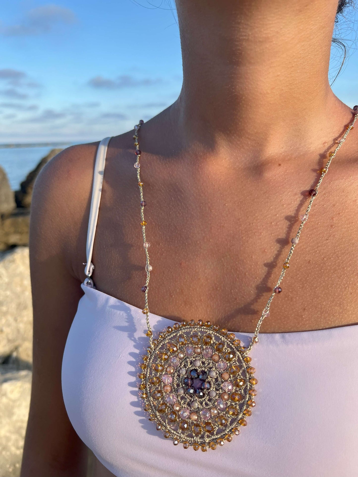 Collana lunga elegante in stile boho con grande ciondolo mandala all’uncinetto e cristalli luminosi. Un gioiello handmade che incanta.