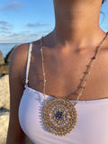 Collana lunga elegante in stile boho con grande ciondolo mandala all’uncinetto e cristalli luminosi. Un gioiello handmade che incanta.