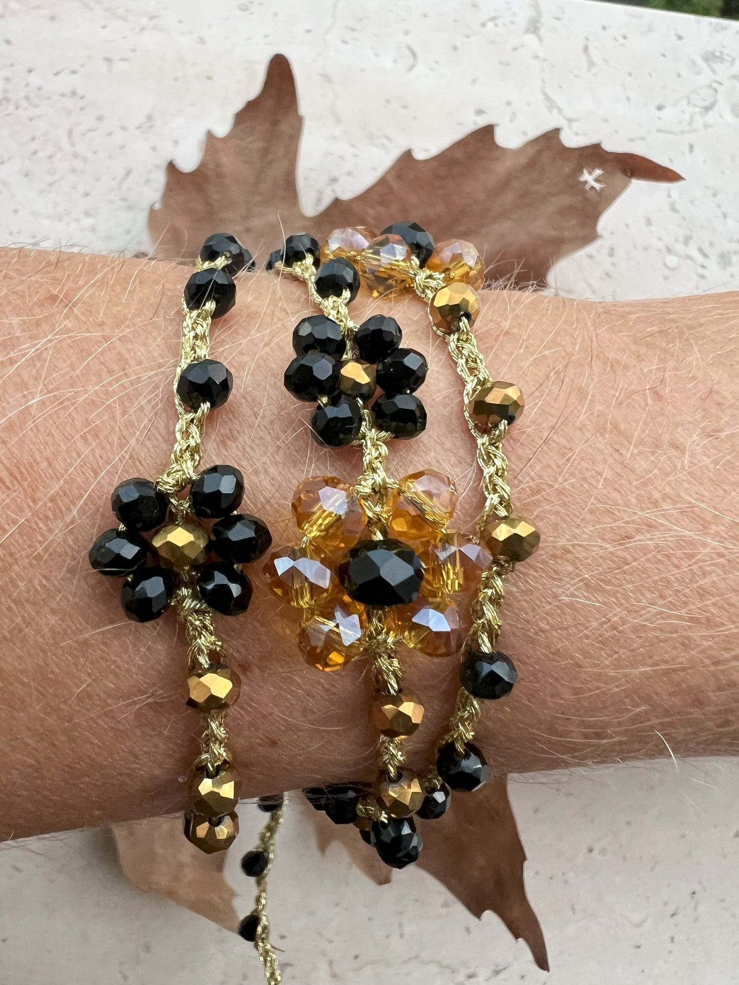 Collana lunga boho chic in oro nero con cristalli e fiori, versatile da indossare come collana o bracciale wrap, perfetta per aggiungere un tocco di eleganza e personalità al tuo look.