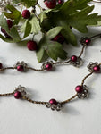 Collana lunga senza chiusura, con perle di vetro color vino e cristalli. Un gioiello elegante che avvolge il collo con stile e bellezza naturale
