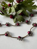 Collana lunga senza chiusura, con perle di vetro color vino e cristalli. Un gioiello elegante che avvolge il collo con stile e bellezza naturale