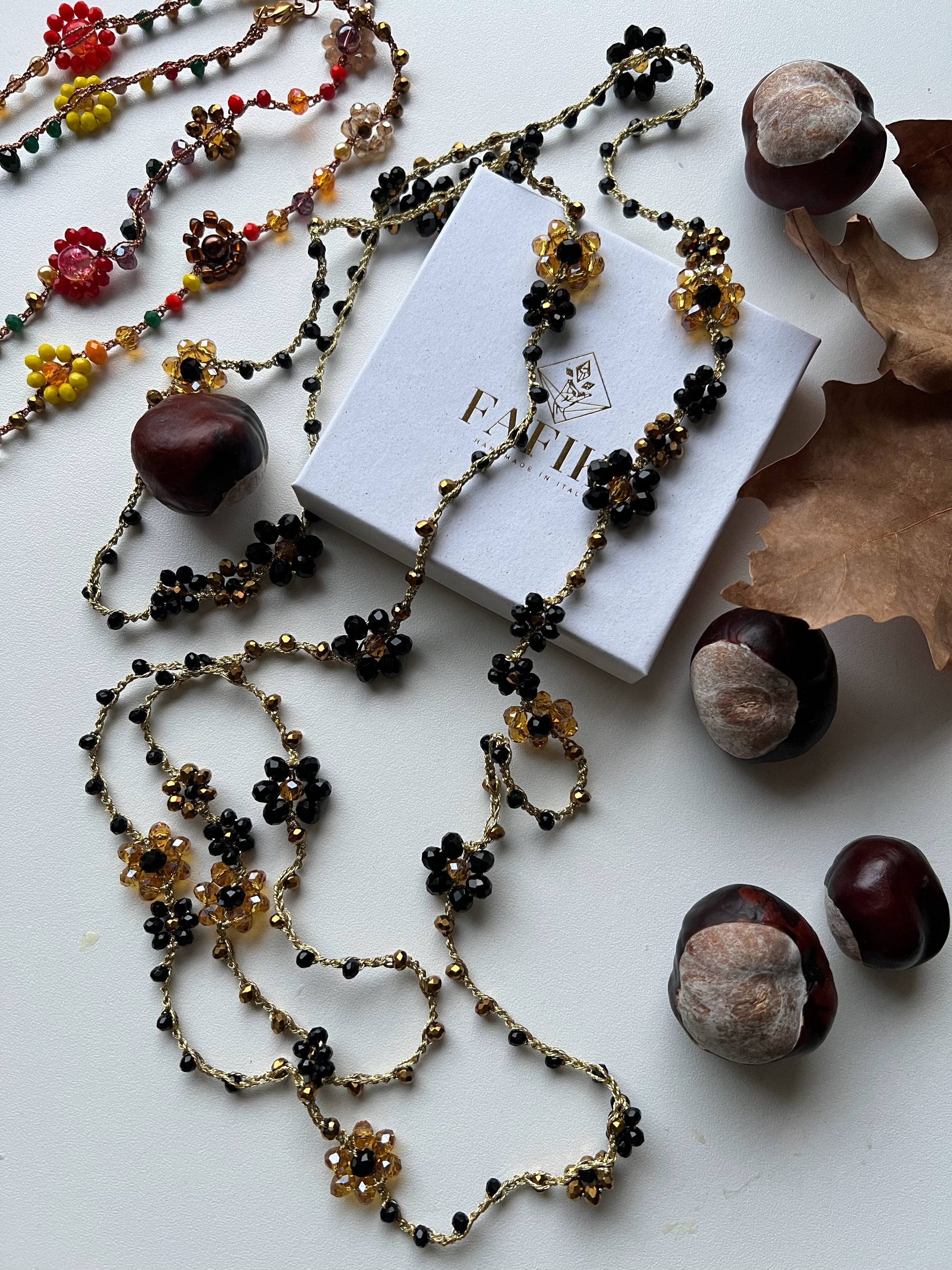 Collana lunga boho chic in oro nero con cristalli e fiori, versatile da indossare come collana o bracciale wrap, perfetta per aggiungere un tocco di eleganza e personalità al tuo look.