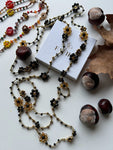 Collana lunga boho chic in oro nero con cristalli e fiori, versatile da indossare come collana o bracciale wrap, perfetta per aggiungere un tocco di eleganza e personalità al tuo look.