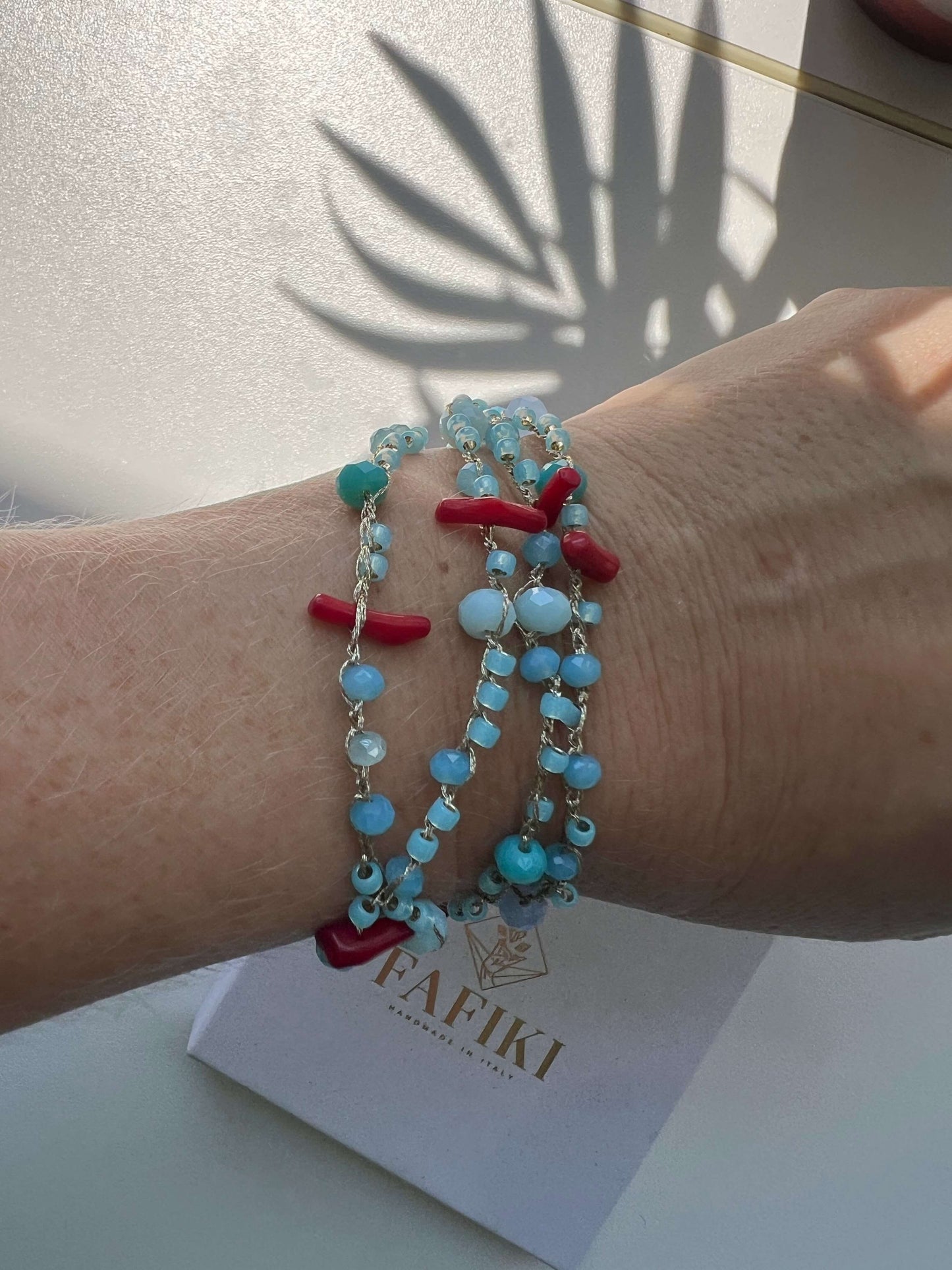 Collana boho chic senza metalli con coralli rossi, cristalli e perline azzurre. Lunga 80 cm, leggera e ideale per pelli sensibili e stile estivo.