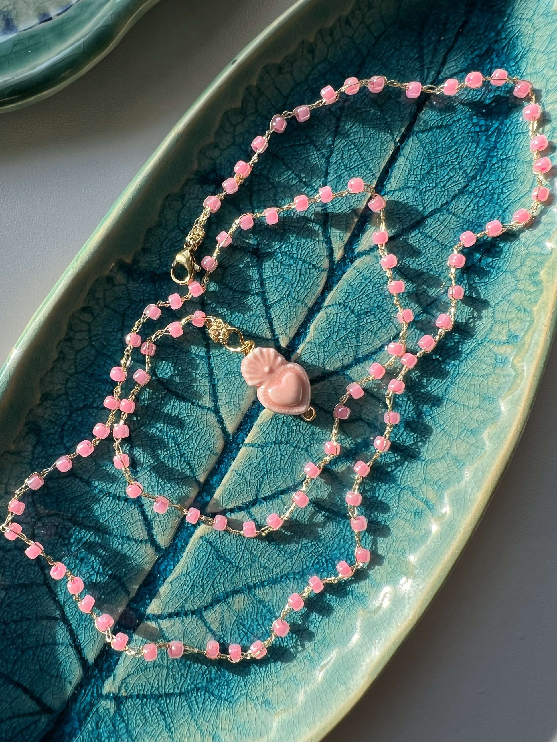 Collana artigianale con cuore sacro colorato. Design essenziale e senza tempo, ideale per look quotidiani.