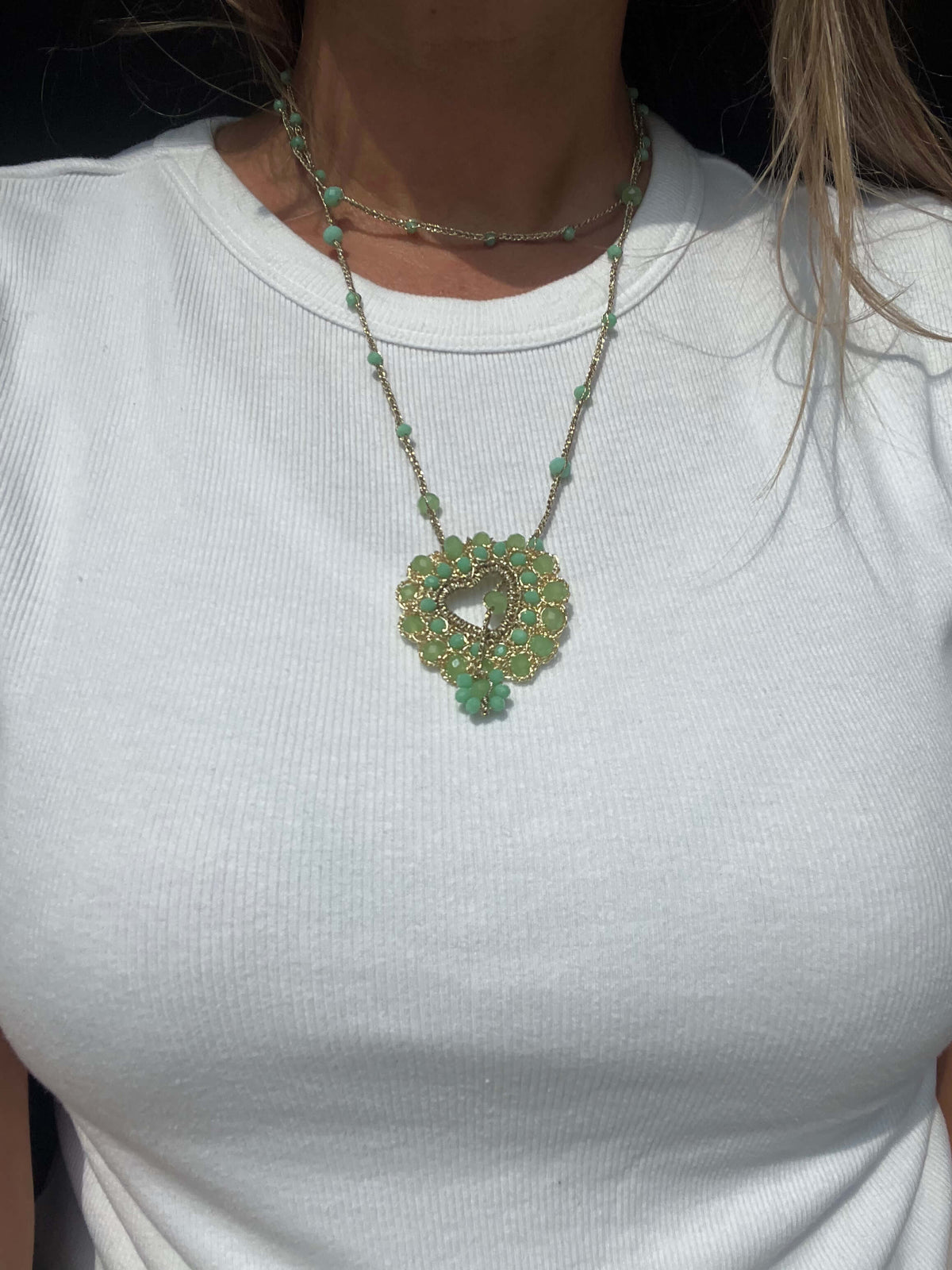 Collana lunga con cuore verde, gioiello artigianale delicato per un look femminile.