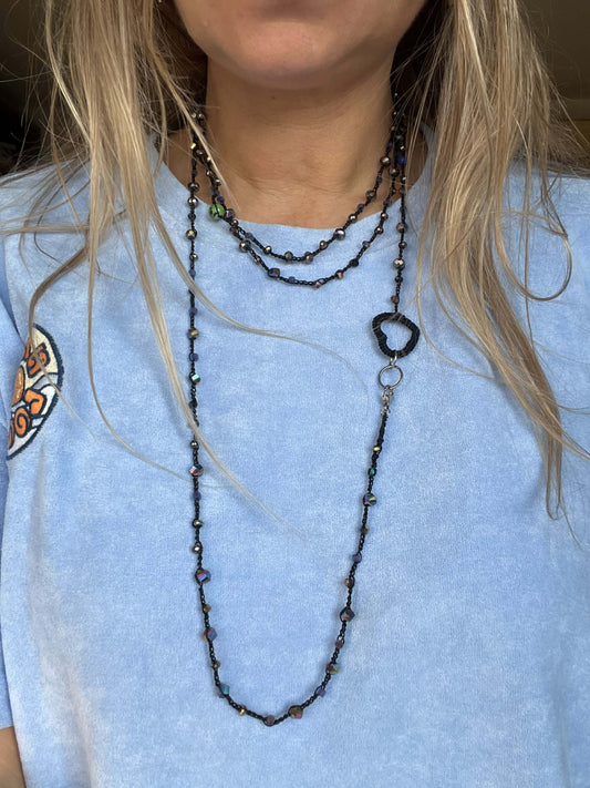 Collana lunga nera artigianale con cuore e cristalli viola. Pezzo unico fatto a mano, elegante e versatile, indossabile a più giri.