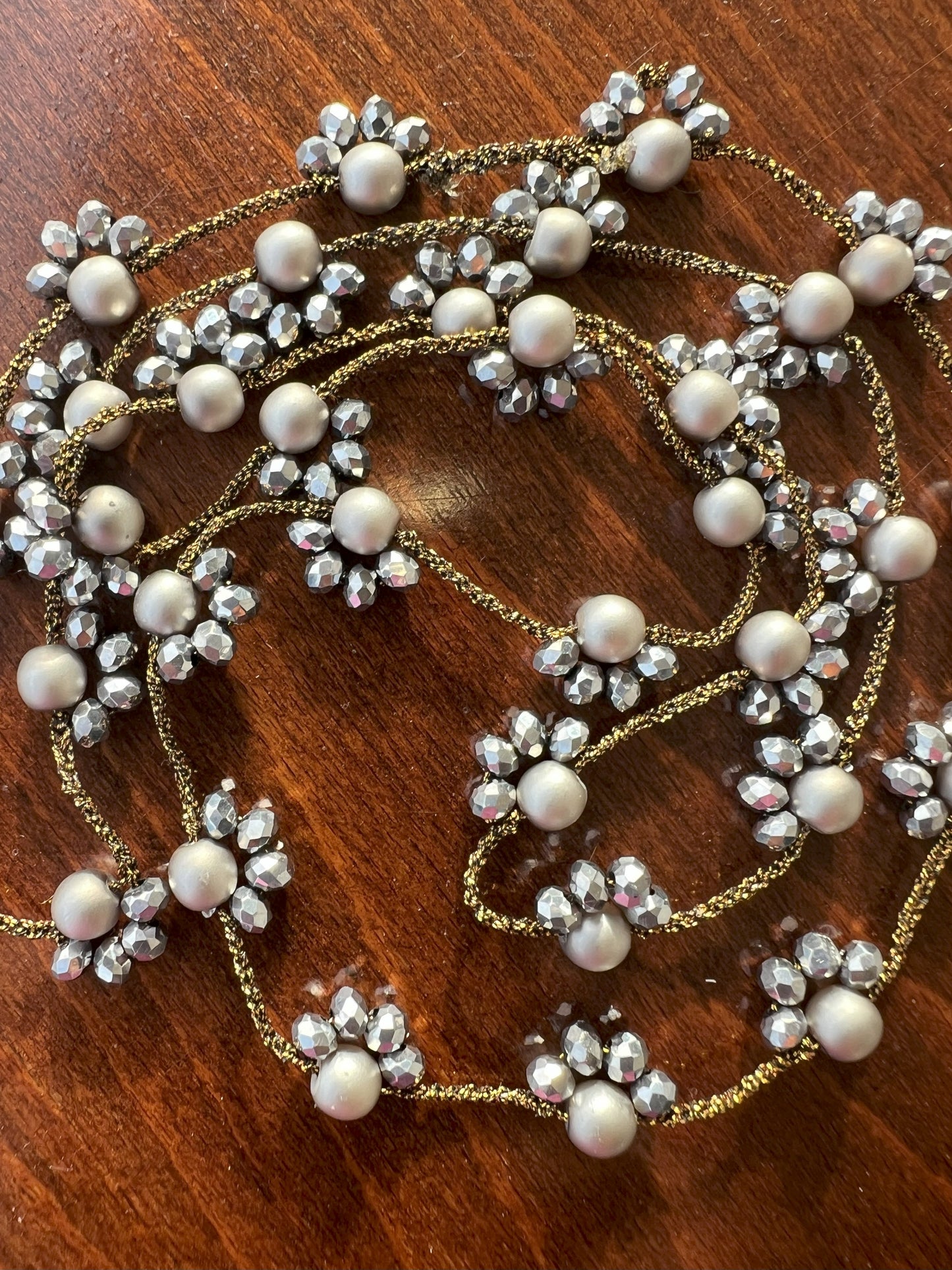 Collana lunga artigianale Filo di Luna in filato gioiello oro-bronzo con cristalli argento e perle di vetro argentato opaco. Accessorio elegante e versatile, indossabile come collana o bracciale avvolgente, perfetta per ogni occasione e stile. Gioiello unico e raffinato, ideale come regalo speciale.