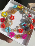 Collana artigianale Primavera Improvvisa: girocollo in uncinetto con fiori colorati rosa, viola e giallo. Convertibile in bracciale a tre giri, 61cm di lunghezza