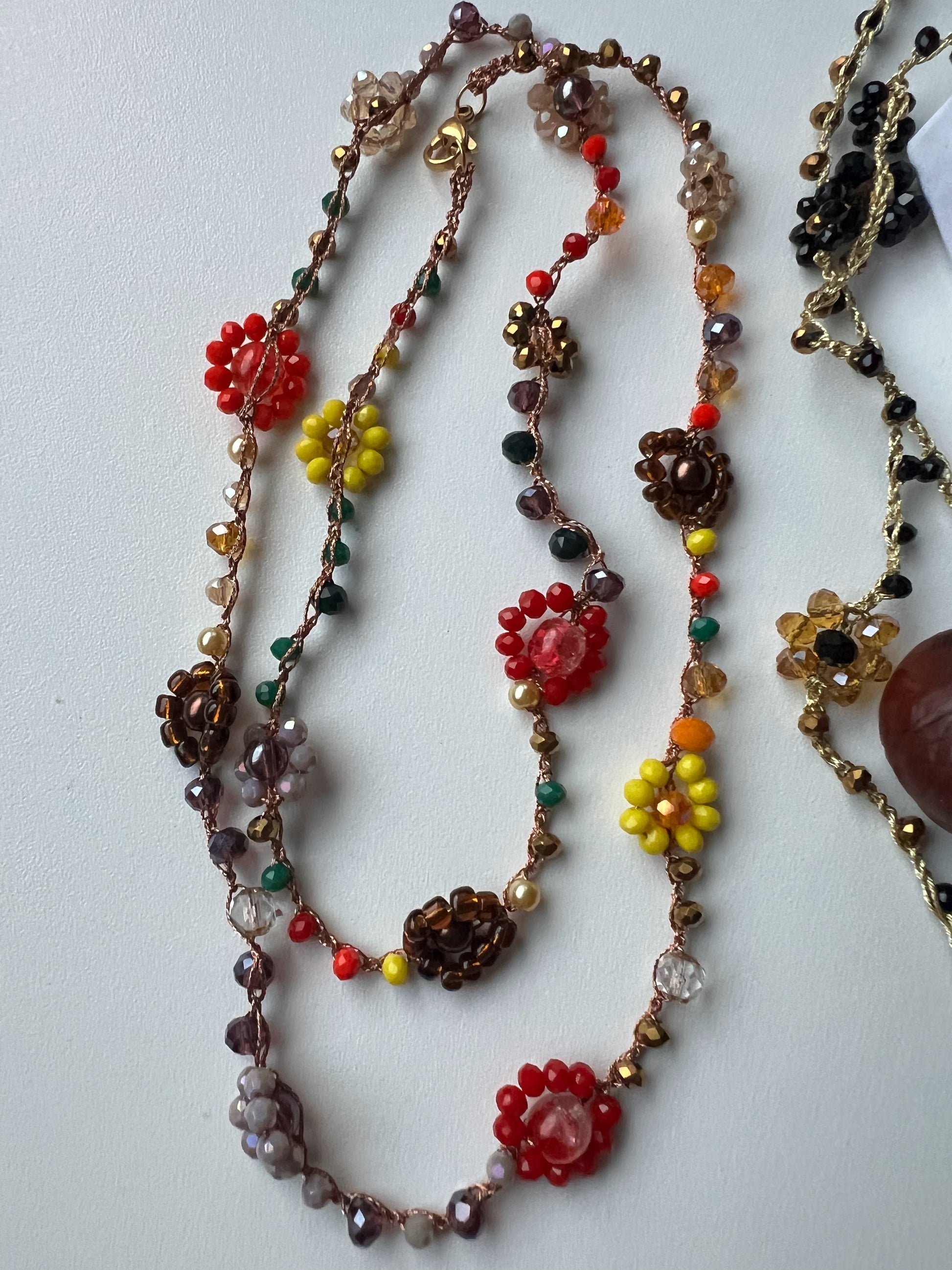 Girocollo "Essenza d'Autunno" realizzato a mano con fiori naturali e perle in tonalità calde, ispirato ai colori dell'autunno. Versatile e regolabile, può essere indossato come collana o bracciale avvolgente, perfetto per ogni occasione. Un accessorio unico che riflette la bellezza naturale e l'eleganza, ideale per chi desidera esprimere la propria personalità attraverso gioielli artigianali.